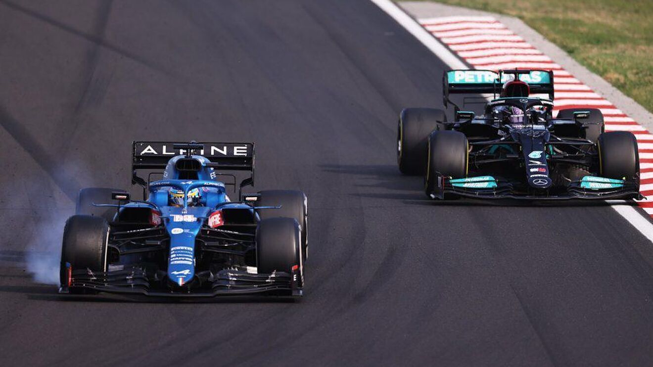 Imagen de la disputa en la pista entre los campeones Lewis Hamilton en el Mercedes y Fernando Alonso durante la carrera en el GP de Hungría de 2021.