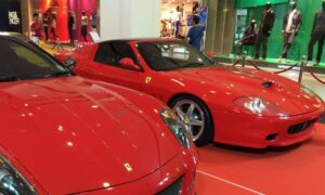 Foto de dos coches clásicos de la marca italiana ferrari de color rojo, en una exposición exclusiva de coches antiguos.