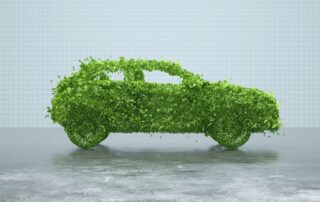 Imagen del lateral derecho de la silueta de un coche hecho de hojas para representar la sostenibilidad de los coches eléctricos e híbridos sobre un fondo gris claro.