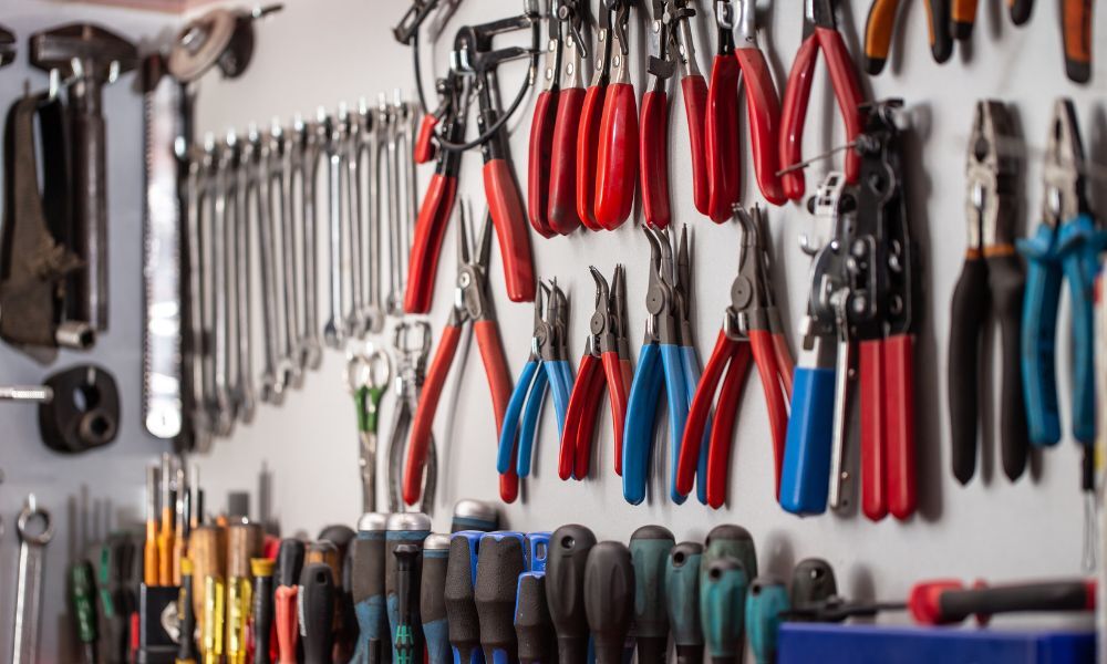 Foto de la pared de un taller mecánico donde están espuertas las herramientas utilizadas para la reparación de averías de coches. 
