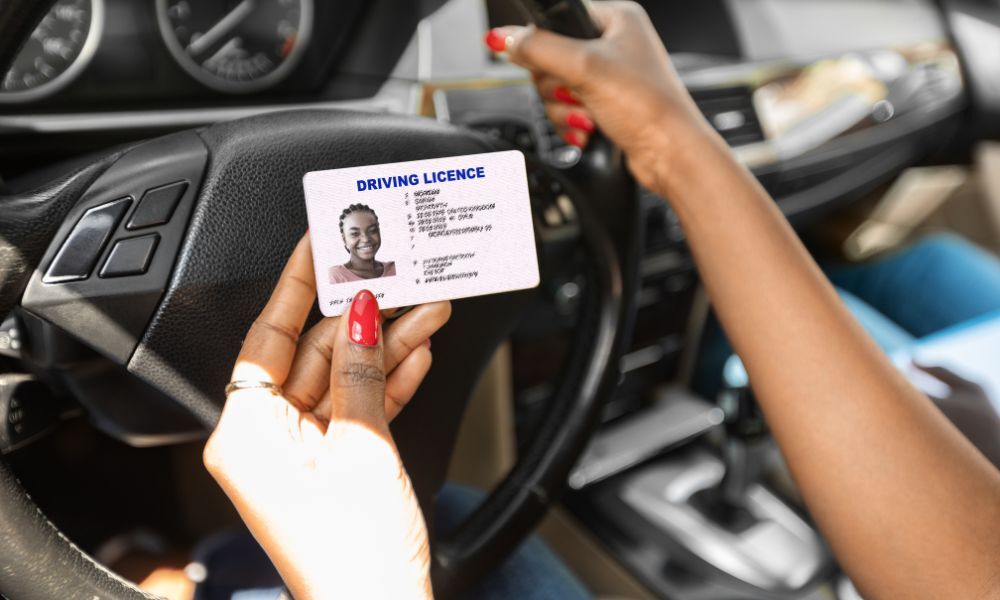 Detalle de la mano de una mujer sosteniendo una licencia de conducir para ilustrar el post: cómo sacar el carnet de conducir internacional.